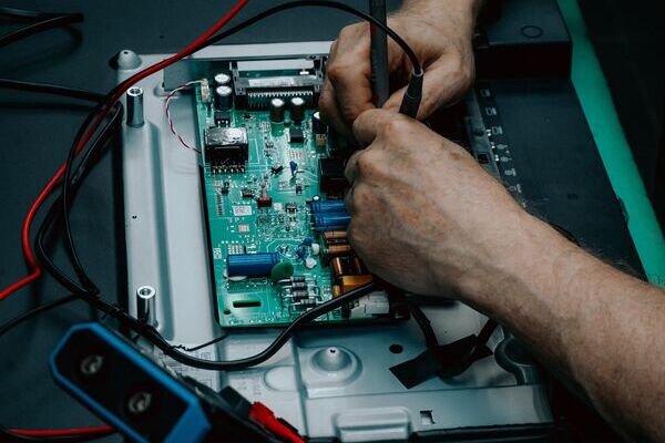 Professional technician tests automotive?pcb circuit?board using multimeter probes to verify electronic?component performance