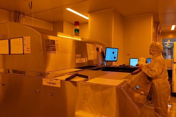 Factory worker performs PCB developing process on production site