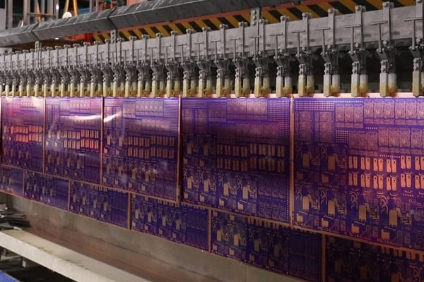 Factory worker conducting electroplating process for printed circuit boards in workshop
