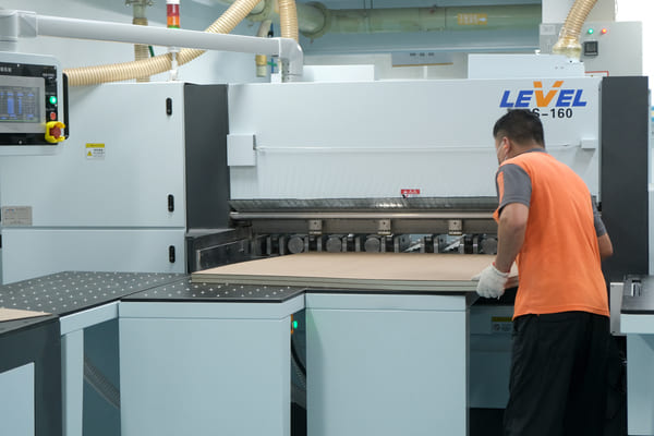 PCBgogo Factory worker feeds FR?4 substrate board into LEVEL S?160 cutting machine for PCB base?material opening procedure at circuit?board production workshop