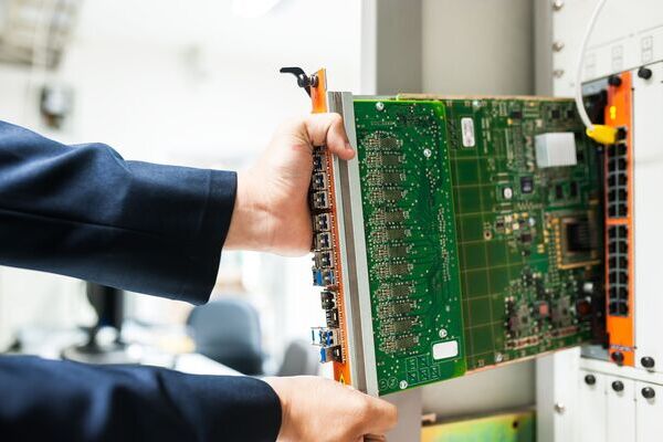 Technician installing modular network switch line card PCB